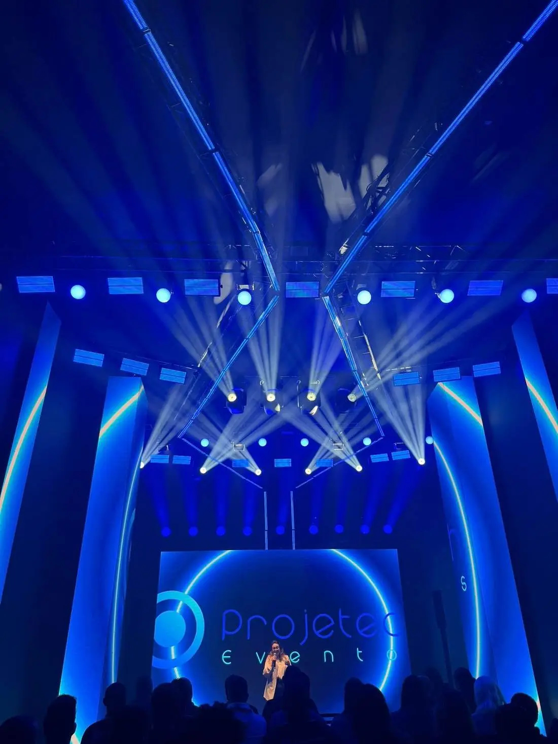 Palco de evento corporativo com painéis de LED e iluminação cênica